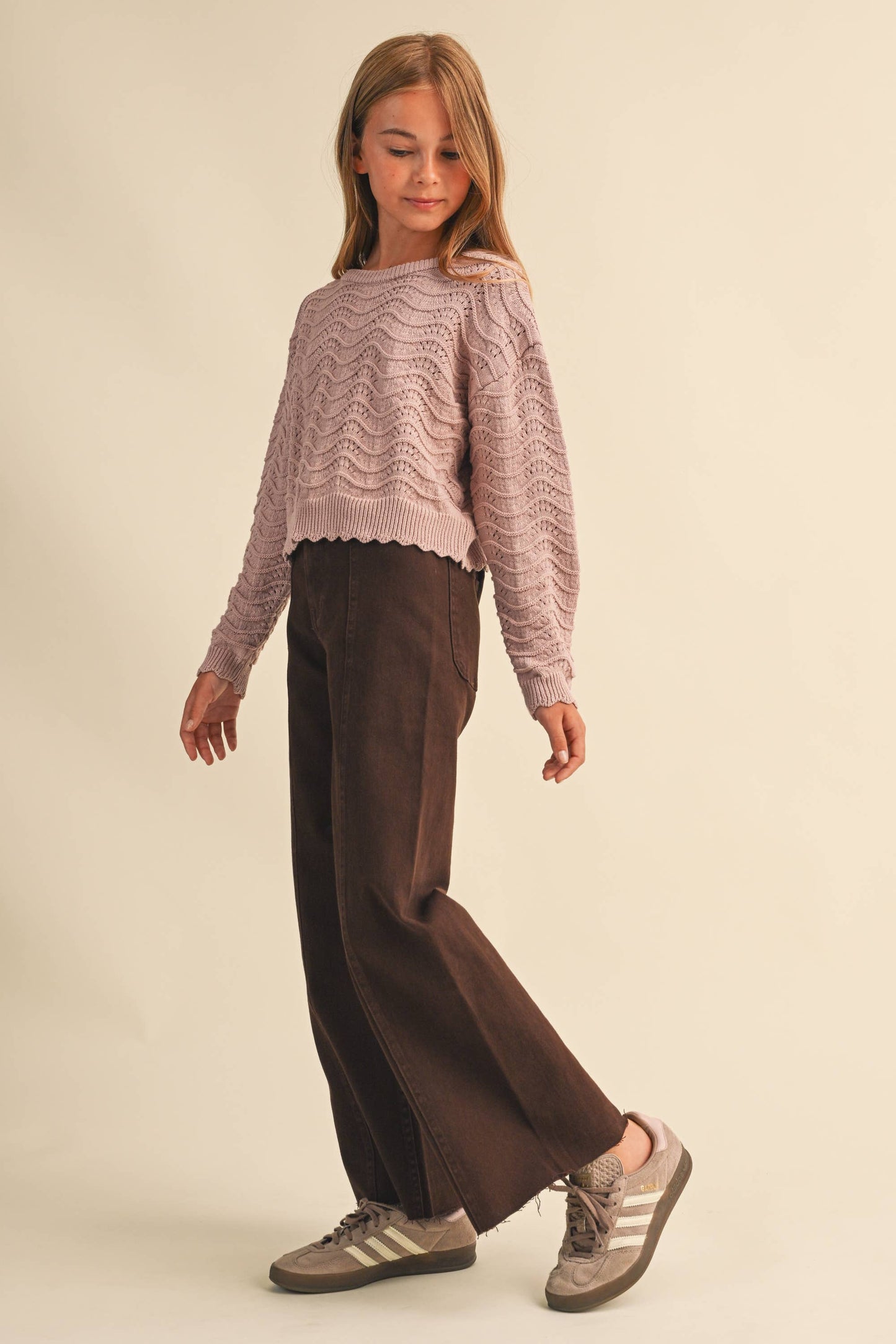 A young girl modeling a mauve knit sweater 